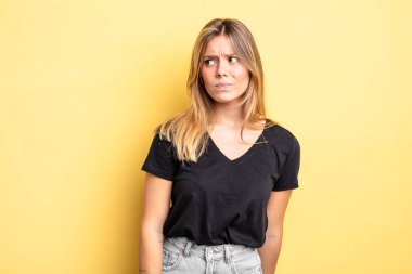 Sarışın, güzel bir kadın üzgün, üzgün ya da kızgın ve olumsuz bir tavır takınıyor, anlaşmazlık içinde kaşlarını çatıyor.