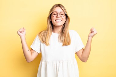 Sarışın, güzel bir kadın son derece mutlu ve şaşırmış görünüyor, başarıyı kutluyor, bağırıyor ve zıplıyor.