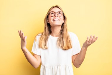 Sarışın, güzel bir kadın kendini mutlu, şaşkın, şanslı ve şaşırmış hissediyor. Zaferi iki eli havada kutluyor.