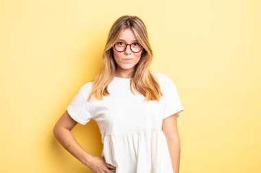 sarışın güzel bir kadın gururlu, kendinden emin, havalı, küstah ve kibirli görünüyor, gülümsüyor, başarılı hissediyor.