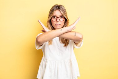 Sarışın, güzel bir kadın senin tavırlarından rahatsız ve bıkkın görünüyor. Yeter artık! Eller önde çapraz, durmanı söylüyor.