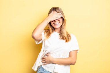 Sarışın, güzel bir kadın stresli, utanmış ya da üzgün görünüyor, baş ağrısı var, yüzünü eliyle kapatıyor.