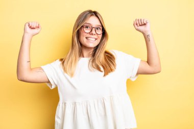 Sarışın, güzel bir kadın muzaffer bir şekilde bağırıyor. Heyecanlı, mutlu ve şaşkın bir kazanan gibi görünüyor.