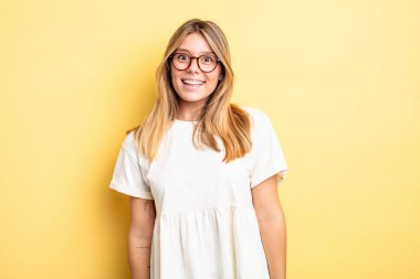 Sarışın, güzel bir kadın. Büyük, dostane, kaygısız bir gülümsemesi var. Olumlu, rahat ve mutlu görünüyor.