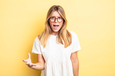 Sarışın, güzel bir kadın sinirli, sinirli ve sinirlenmiş görünüyor. 