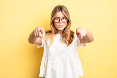 Sarışın, güzel bir kadın kamerayı iki parmağıyla ve kızgın bir ifadeyle sana görevini yapmanı söylüyor.