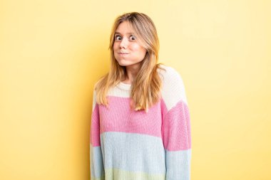 Sarışın, güzel bir kadın. Aptal, çılgın, şaşırmış bir ifade. Yanakları şişmiş, doldurulmuş, şişman ve yemekle dolu.