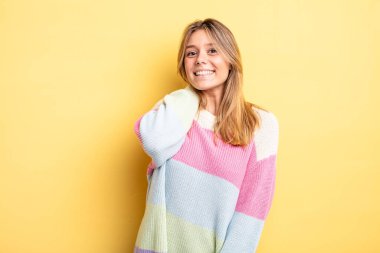 Sarışın, güzel bir kadın neşeli ve kendinden emin bir şekilde gülüyor, mutlu, dostane bir gülümsemeyle.