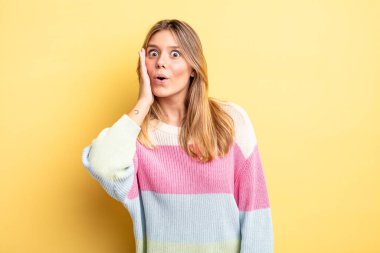 Sarışın, güzel bir kadın şoke olmuş ve ağzı açık bir şekilde yüz yüze inanamamaktan şaşkına dönmüş.