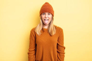 Sarışın, güzel bir kadın tiksinmiş ve rahatsız olmuş hissediyor, dilini dışarı çıkarıyor, iğrenç ve iğrenç bir şeyden hoşlanmıyor.