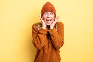 Sarışın, güzel bir kadın beklenmedik bir sürpriz yüzünden şaşkın, heyecanlı, gülen, şaşkın ve mutlu hissediyor.