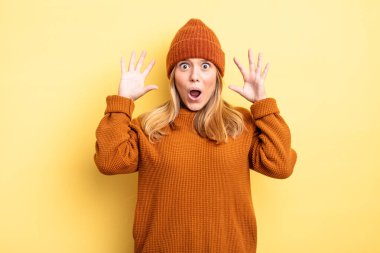 Sarışın, güzel bir kadın elleri havada bağırıyor. Öfkeli, sinirli ve üzgün.