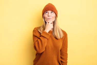 Sarışın, güzel bir kadın. Düşünüyor, kuşkulu ve kafası karışık. Farklı seçenekleri var.