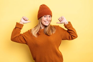 Sarışın, güzel bir kadın gururlu, kibirli ve kendinden emin, tatmin olmuş ve başarılı görünüyor, kendini gösteriyor.