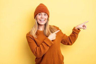 Sarışın, güzel bir kadın. Neşeli ve şaşırmış hissediyor. Şok olmuş bir ifadeyle gülümsüyor.