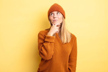 Sarışın, güzel bir kadın düşünceli, meraklı ya da hayalperest düşünceler kuruyor, hayal kuruyor ve mekanı kopyalamak için yukarı bakıyor.