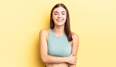 İspanyol güzel kadın utangaç ve neşeli bir şekilde gülüyor, arkadaş canlısı ve olumlu ama güvensiz bir tavırla.