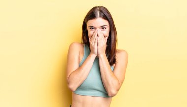 İspanyol güzel kadın mutlu, neşeli, şanslı ve şaşkın görünüyor. İki eliyle ağzını kapatıyor.