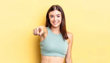 İspanyol güzel kadın kameraya tatmin olmuş, kendine güvenen, dost canlısı bir gülümsemeyle bakıyor ve seni seçiyor.