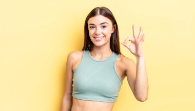 İspanyol güzel kadın kendini mutlu, rahat ve tatmin olmuş hissediyor. Onayını iyi bir hareketle gösteriyor. Gülümsüyor.