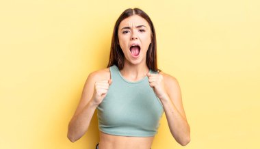 İspanyol asıllı güzel bir kadın sinirli, sinirli bakışlar ve sıkı yumruklar ile agresif bir şekilde bağırıyor.