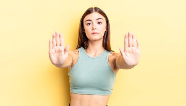 İspanyol güzel kadın ciddi, mutsuz, kızgın ve hoşnutsuz görünüyor. Girmeyi yasaklıyor ya da iki avucunun içinde de dur diyor.