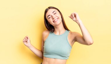 İspanyol güzel kadın gülümsüyor, kaygısız hissediyor, rahat ve mutlu, dans ediyor ve müzik dinliyor, bir partide eğleniyor.