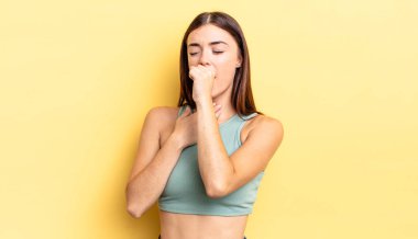 Boğazı ağrıyan ve grip belirtileri gösteren, ağzı kapalı öksüren İspanyol güzel bir kadın.