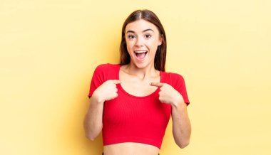 İspanyol güzel kadın mutlu, şaşkın ve gururlu hissediyor, heyecanlı, şaşkın bakışlarla kendini işaret ediyor.