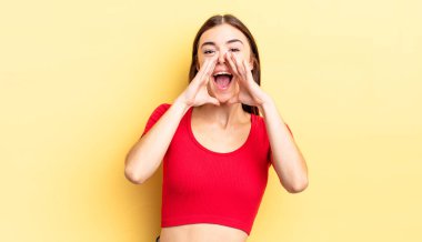 İspanyol güzel kadın mutlu, heyecanlı ve pozitif hissediyor. Elleri ağızda, bağırarak bağırıyor.