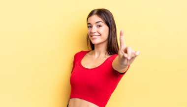 İspanyol güzel kadın gururla gülümsüyor ve bir numaralı pozu başarıyla veriyor, kendini lider gibi hissediyor.