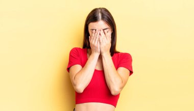 Hispanik güzel kadın üzgün, hayal kırıklığına uğramış, gergin ve depresif, iki eliyle yüzünü kaplayan, ağlayan