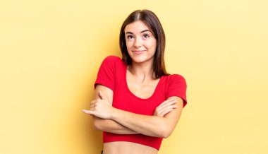 İspanyol güzel kadın omuz silkiyor, kafası karışık ve emin değil, kolları bağlı ve şaşkın görünüyor.