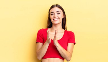 İspanyol güzel kadın mutlu ve başarılı hissediyor, gülümsüyor ve alkışlıyor, alkışlarla tebrik ediyor.