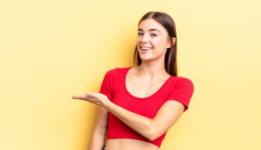 İspanyol güzel kadın neşeyle gülümsüyor, mutlu hissediyor ve fotokopi uzayda bir konsept gösteriyor.