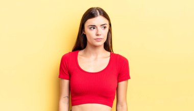 Hispanik güzel kadın üzgün, üzgün ya da kızgın hissediyor ve olumsuz bir tutumla yan yana bakıyor, anlaşmazlık içinde kaşlarını çatıyor