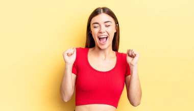 İspanyol güzel kadın son derece mutlu ve şaşırmış görünüyor, başarıyı kutluyor, bağırıyor ve zıplıyor.