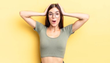 İspanyol güzel kadın heyecanlı ve şaşırmış görünüyor, ağzı açık, iki eli de başında, kendini şanslı hissediyor.