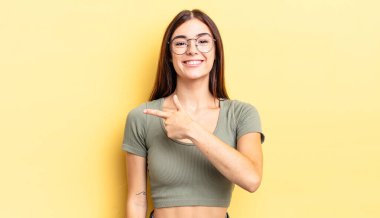 İspanyol güzel kadın heyecanlı ve şaşırmış görünüyor. Yana ve yukarı doğru uzayı gösteriyor.