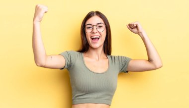 İspanyol güzel kadın muzaffer bir şekilde bağırıyor. Heyecanlı, mutlu ve şaşırmış görünüyor. Kutlama yapıyor.