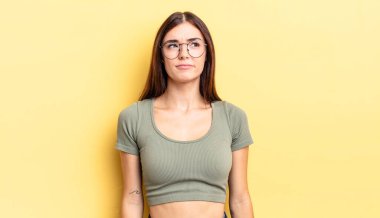 İspanyol güzel kadın şaşkın ve şaşkın görünüyor, merak ediyor veya bir sorunu çözmeye çalışıyor ya da düşünüyor.