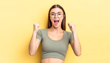 İspanyol güzel kadın mutlu, şaşırmış ve gururlanmış hissediyor, bağırıyor ve başarıyı büyük bir gülümsemeyle kutluyor.