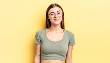 İspanyol güzel kadın mutlu ve arkadaş canlısı görünüyor, gülümsüyor ve pozitif bir tavırla sana göz kırpıyor.