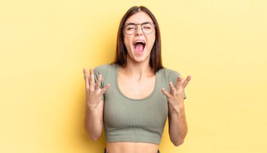 İspanyol güzel kadın öfkeyle bağırıyor, stresli hissediyor ve ellerini havaya kaldırıp neden ben diye bağırıyor.