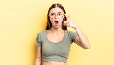 Kızgın, çılgın bir patrona benzeyen sinirli bir ifadeyle kameraya bakan İspanyol güzeli bir kadın.