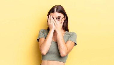 İspanyol güzel kadın korkmuş ya da utanmış hissediyor, gözleri yarı kapalı ya da elleri kapalı dikizliyor ya da dikizliyor.