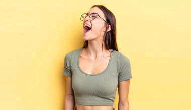 İspanyol güzel kadın öfkeyle bağırıyor, agresif bir şekilde bağırıyor, stresli ve kızgın görünüyor.