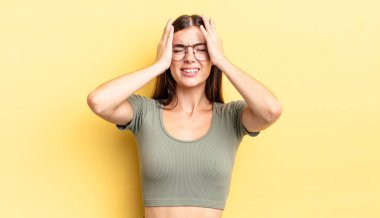 İspanyol güzel kadın stresli ve endişeli, depresif ve hayal kırıklığına uğramış hissediyor, iki elini de başa kaldırıyor.