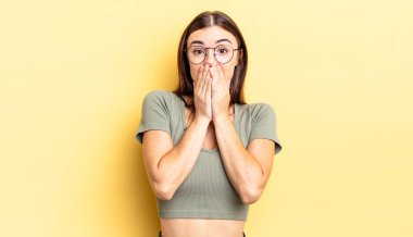 İspanyol güzel kadın mutlu ve heyecanlı, şaşırmış ve şaşırmış elleri ağızda, tatlı bir ifadeyle kıkırdıyor.