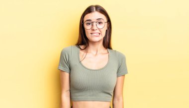 İspanyol güzel kadın şaşkın ve şaşkın görünüyor. Sinirli bir hareketle dudağını ısırıyor. Sorunun cevabını bilmiyor.